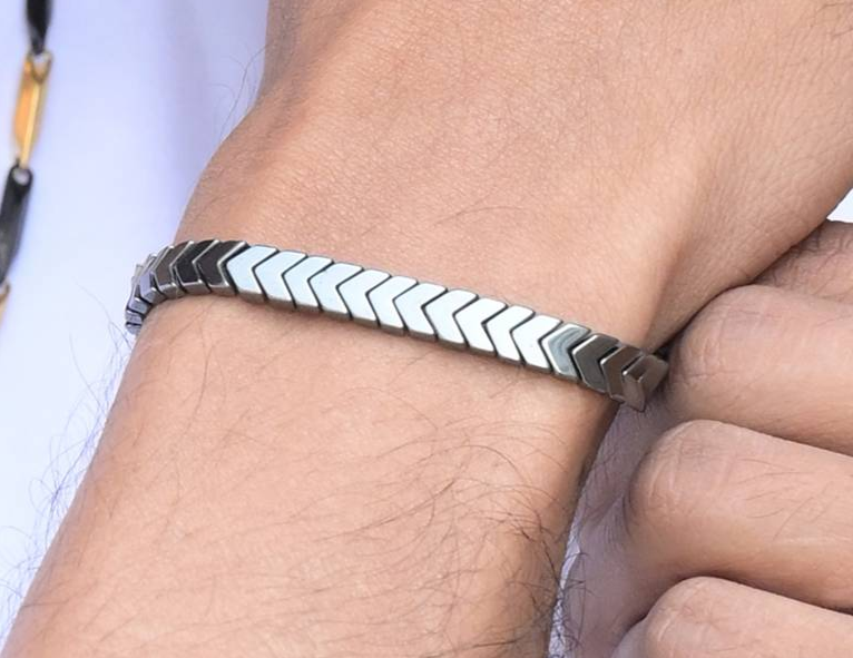 Gray braided bracelet worn on man's wrist with casual styling