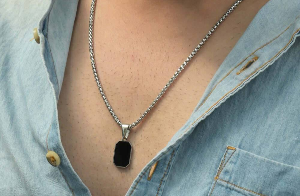 Man wearing silver metal cuff bracelet with casual black clothing